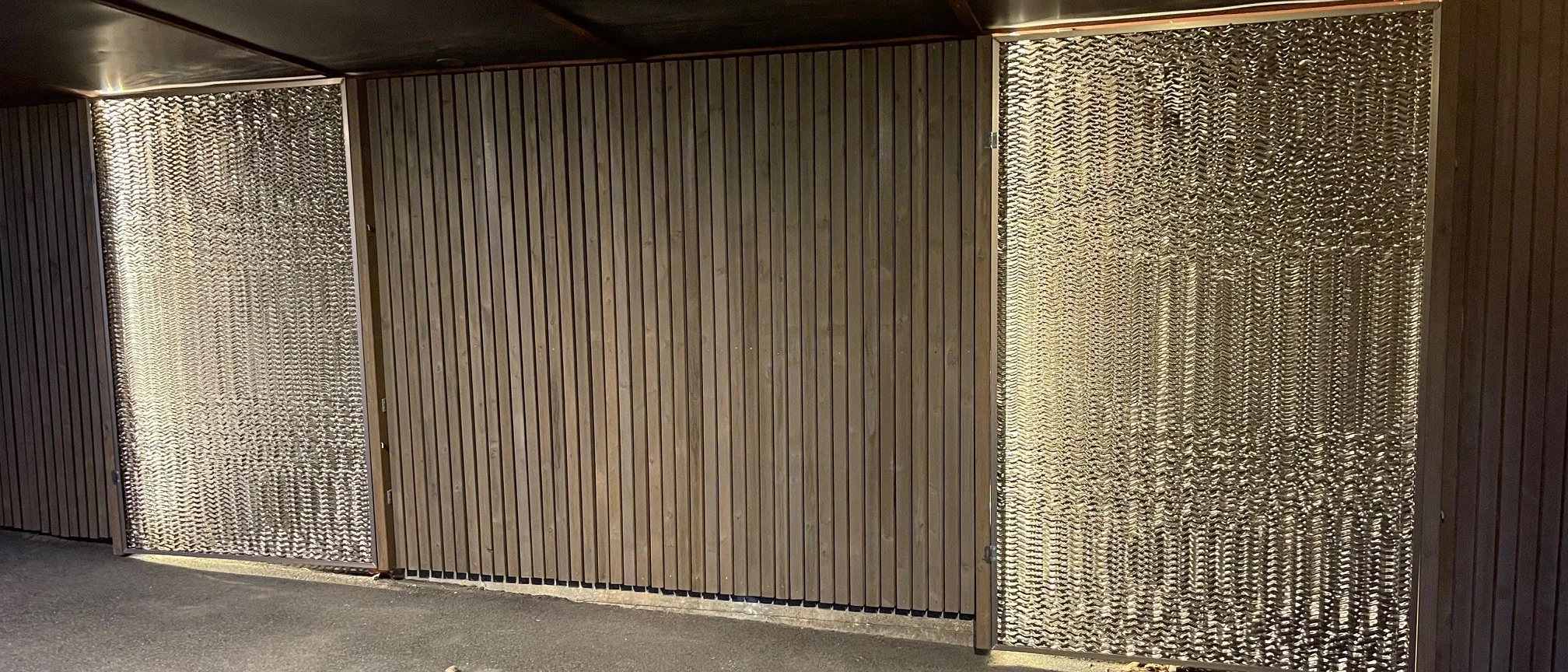 Carport med felt i strekkmetall mellom trespiler