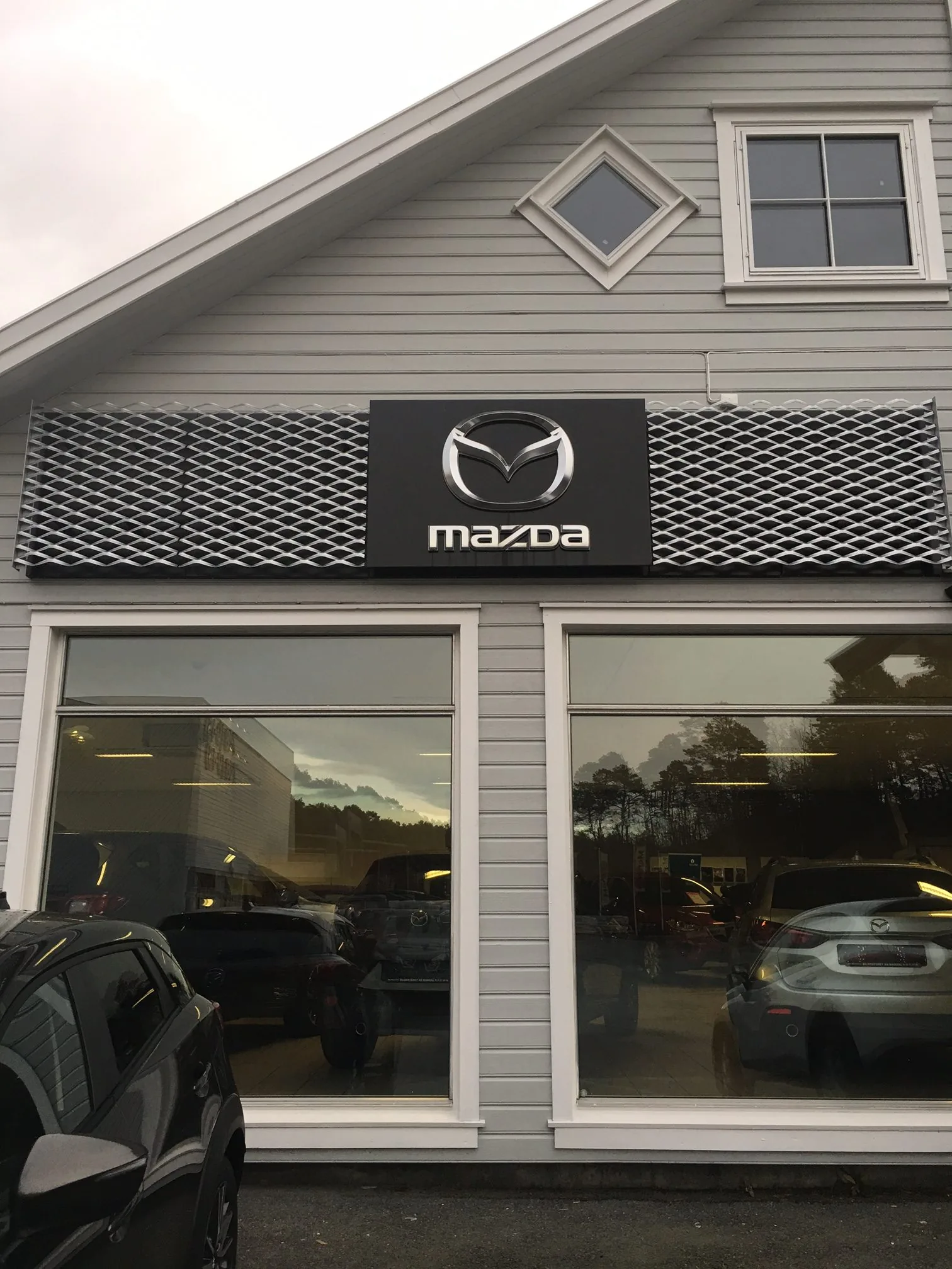 Strekkmetall rundt Mazda-skiltet på en bilforretning